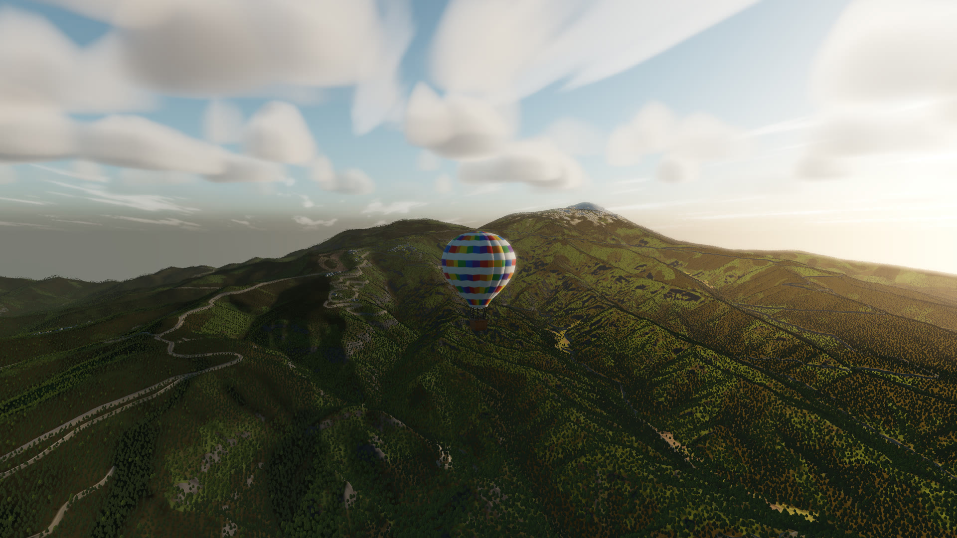 A hot air balloon crossing a mountain ridge in morning light